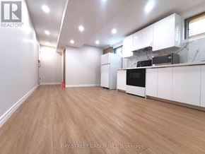 Toronto (Pleasant View) apartment for rent - A spacious kitchen with white cabinets and a wooden floor.