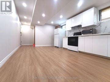 Toronto (Pleasant View) apartment for rent - A spacious kitchen with white cabinets and a wooden floor.