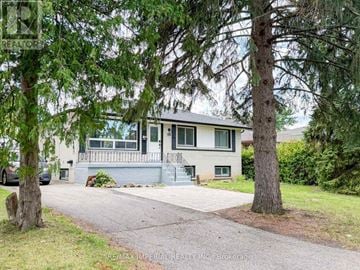 Richmond Hill (Crosby) apartment for rent - A house with a grey roof and a white wall is surrounded by trees.