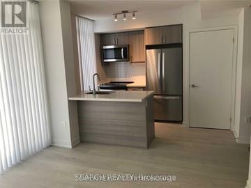 Toronto (Church-Yonge Corridor) condo for rent - A modern kitchen with a stainless steel refrigerator and a microwave above the stove.