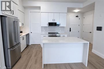 Guelph condo for rent - A white kitchen with a refrigerator and a counter.