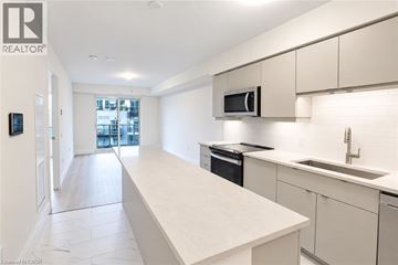 Guelph condo for rent - A modern kitchen with white cabinets and appliances.