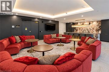 Guelph condo for rent - A living room with red couches and a TV.