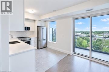 Guelph condo for rent - A modern kitchen with white cabinets and a view of the city.