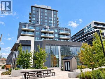 Guelph condo for rent - A modern building with glass windows and a wooden entrance.
