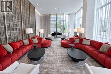 Guelph condo for rent - A living room with red couches and a piano.