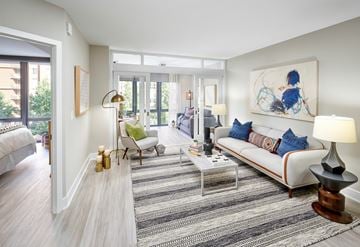 Washington apartment for rent - A living room with a white couch and a painting on the wall.