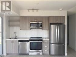 Toronto (Church-Yonge Corridor) condo for rent - A modern kitchen with stainless steel appliances and white cabinets.