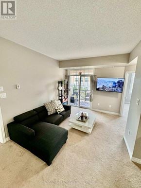 Oakville (Ro River Oaks) townhouse for rent - A living room with a black couch and a flat screen TV mounted on the wall.