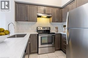 Milton condo for rent - A modern kitchen with a stainless steel refrigerator, oven, and cabinets.