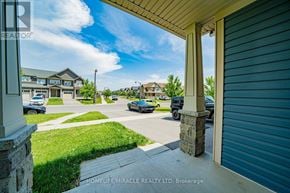 Oshawa (Windfields) townhouse for rent - A view from a house looking out to a street with cars and houses in the background.