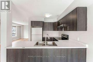 Oshawa (Windfields) townhouse for rent - A modern kitchen with dark brown cabinets and a white countertop.