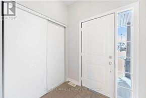 Oshawa (Windfields) townhouse for rent - A white door is open to a balcony with a view of a building.