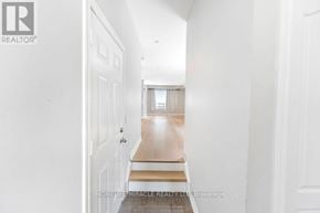 Oshawa (Windfields) townhouse for rent - A long hallway with white walls and a wooden floor.