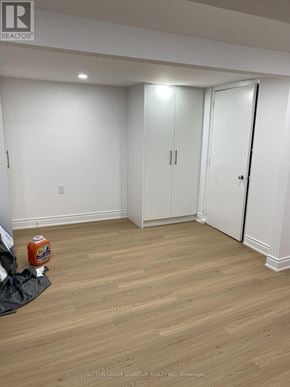 Mississauga (Port Credit) multi-family for rent - A room with a wooden floor and white walls with a door on the right.