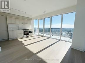 Mississauga (City Centre) condo for rent - A spacious room with a view of the ocean through large windows.