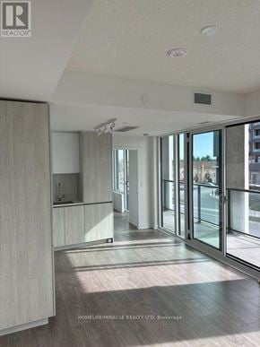 Brampton (Fletcher's Creek South) condo for rent - A spacious, well-lit room with a sliding glass door leading to a balcony.
