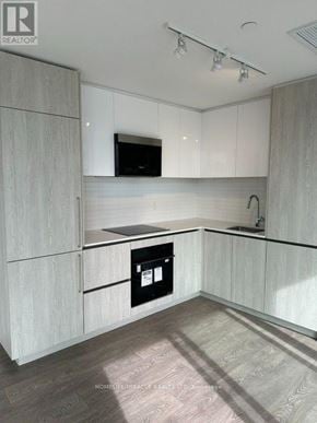 Brampton (Fletcher's Creek South) condo for rent - A modern kitchen with white cabinets and a black oven.