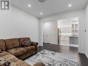 Oshawa (Taunton) apartment for rent - A living room with a brown couch and a rug.