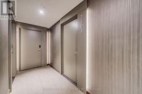 Mississauga (City Centre) condo for rent - A hallway with a carpeted floor and a wall with a wood grain texture.