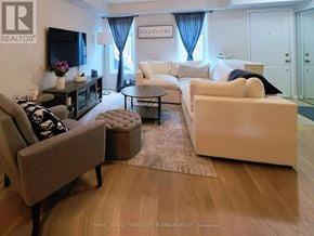 Oakville (Ro River Oaks) condo for rent - A living room with a white couch and a brown armchair.