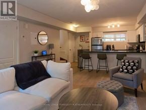 Oakville (Ro River Oaks) condo for rent - A living room with a white couch and a grey armchair.