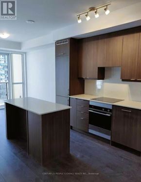 Mississauga (Fairview) condo for rent - A kitchen with dark wood cabinets and a white countertop.