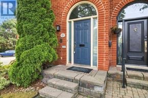 Oakville (Br Bronte) townhouse for rent - A blue door is on the right side of a brick house.