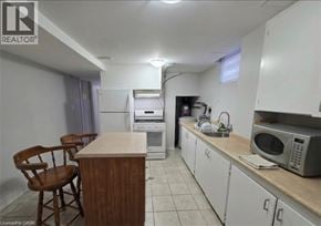 Waterloo apartment for rent - A kitchen with white cabinets and a wooden island with two chairs.