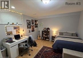Waterloo apartment for rent - A bedroom with a bed, desk, chair, and guitar.