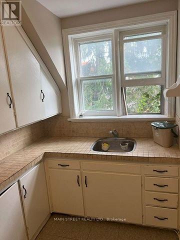 Barrie (Queen's Park) triplex for rent - A kitchen with a window and a sink.