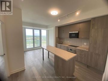 Markham (Unionville) condo for rent - A kitchen with a table and a microwave oven.