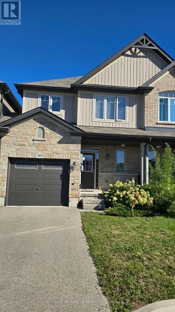 Hamilton (Binbrook) townhouse for rent - A house with a grey garage door and a stone pillar.