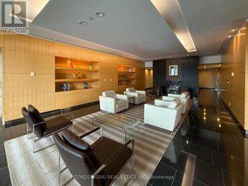 Toronto (Waterfront Communities) condo for rent - A modern living room with a glass table and leather chairs.