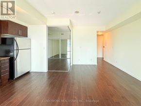 Toronto (Waterfront Communities) condo for rent - A kitchen with a black fridge and wooden floors.