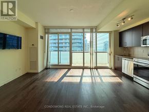 Toronto (Waterfront Communities) condo for rent - A spacious kitchen and living room with wood flooring and large windows.