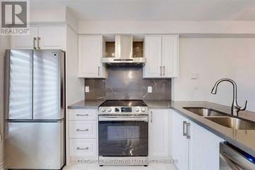 Pickering (Village East) townhouse for rent - A modern kitchen with white cabinets and stainless steel appliances.