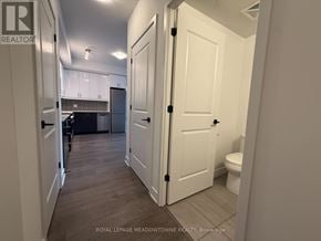 Oakville (Wm Westmount) condo for rent - A white door is open to a kitchen and bathroom.