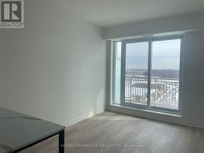 Brampton (Northwest Brampton) condo for rent - A room with a table and a window overlooking a cityscape.