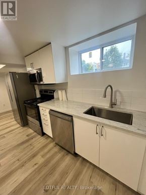 Ottawa apartment for rent - A kitchen with a sink, stove, and cabinets.