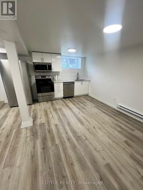 Ottawa apartment for rent - A spacious kitchen with wood flooring and white walls.