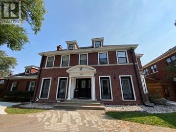 Windsor apartment for rent - A red brick house with a black front door and windows.