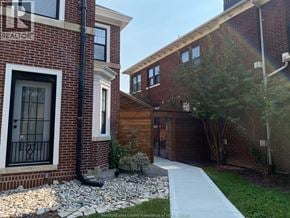 Windsor apartment for rent - A brick house with a white door and a black pipe on the ground.