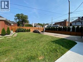 Windsor apartment for rent - A backyard with a lawn and a fence.