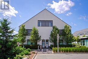 Innisfil townhouse for rent - A modern building with a grey facade and a clear blue sky above.