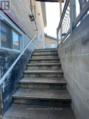 Barrie (Northwest) apartment for rent - A set of stairs leading up to a door with a sign that says "HOMELIFE LANDMARK REALTY INC. Brokerage".
