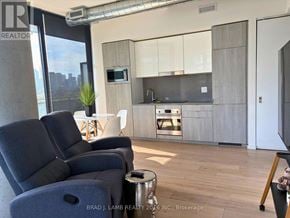 Toronto (Moss Park) condo for rent - A modern living room with a grey sofa and a wooden floor.