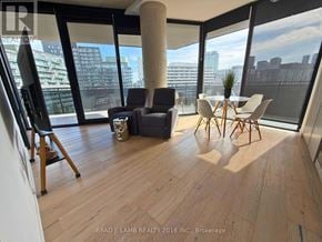 Toronto (Moss Park) condo for rent - A modern living room with a large window overlooking the city.