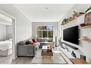 Surrey apartment for rent - A living room with a grey couch and a flat screen TV mounted on the wall.