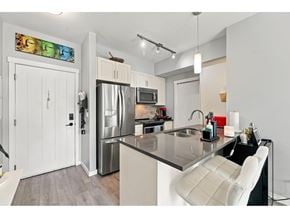 Surrey apartment for rent - A modern kitchen with a refrigerator, microwave, and stove top oven.